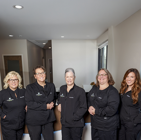 Woman smiling at dental team member