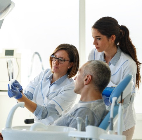 Jeffersonville dentist and hygienist looking at X-rays with patient